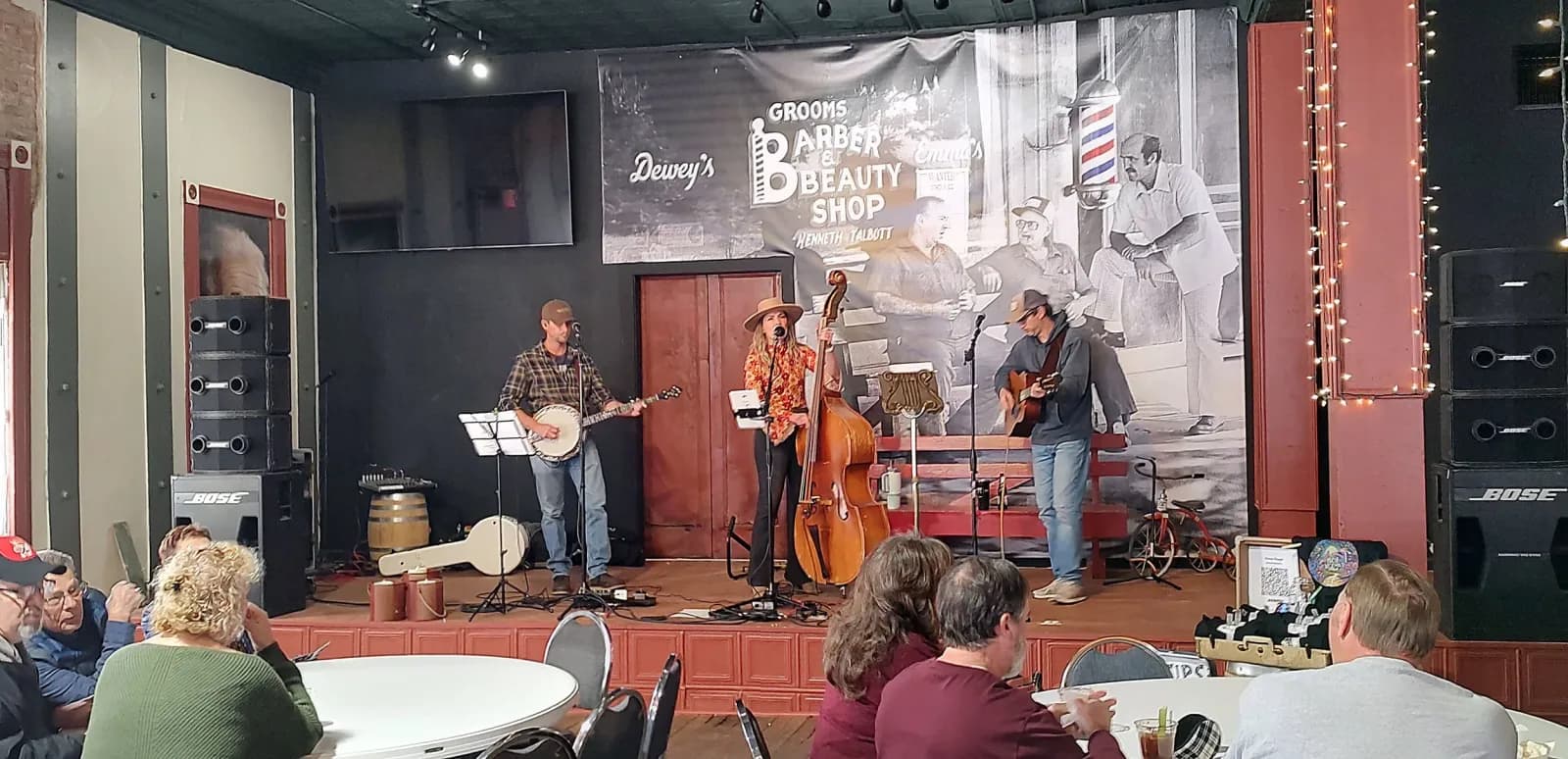 A band performing on stage for an audience at Smoky Valley Distillery